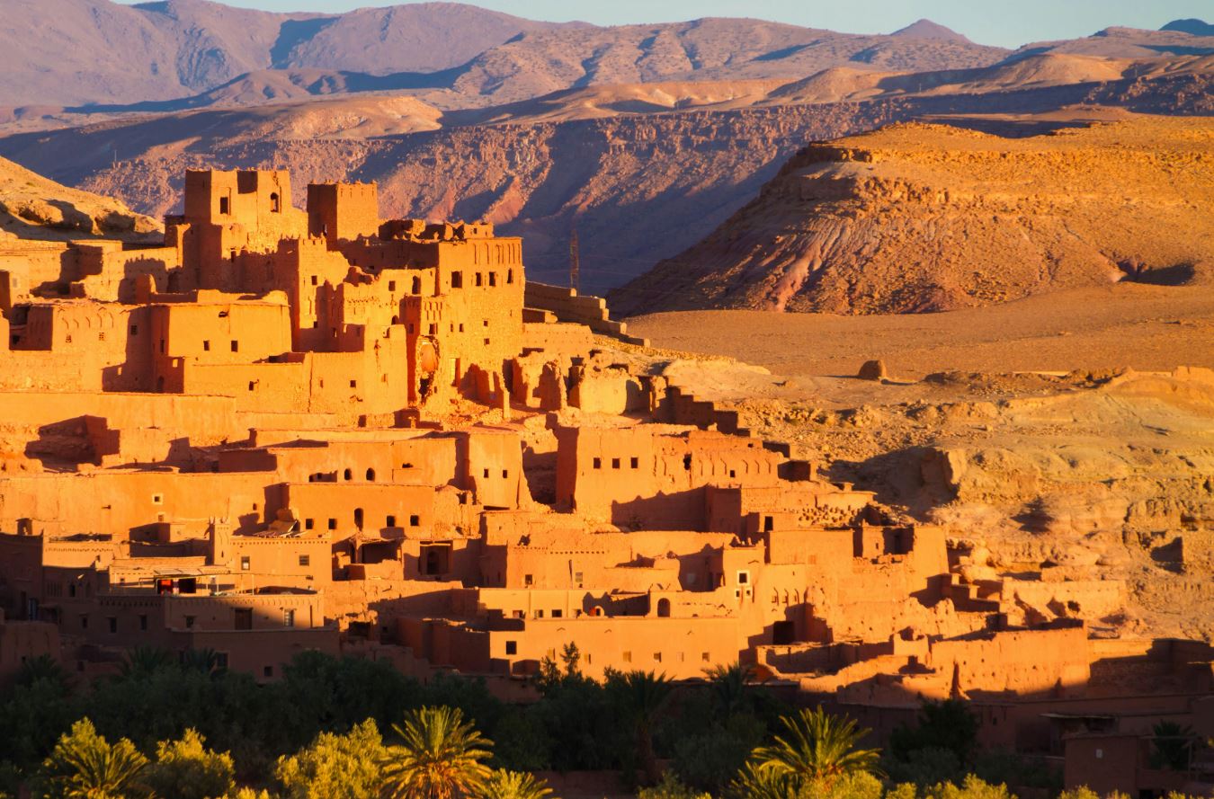 Aerial view of Ouarzazate city in Morocco, showcasing the famous Ait Ben Haddou kasbah, traditional Moroccan architecture, and the surrounding desert landscape.