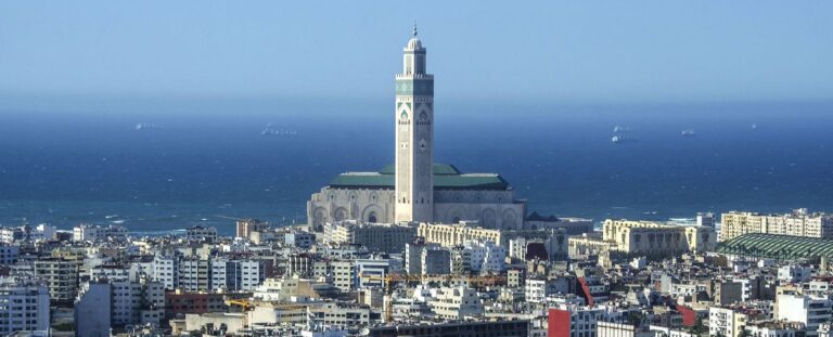 Skyline of Casablanca city, Morocco, showcasing the Hassan II Mosque, modern skyscrapers, and the bustling port along the Atlantic coastline.