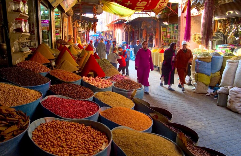 Discover the Magic of Marrakech: Your Ultimate Destination Vibrant street view of Marrakech city, Morocco, showcasing the historic Koutoubia Mosque, bustling souks, and traditional Moroccan architecture against a backdrop of palm trees and the Atlas Mountains.
