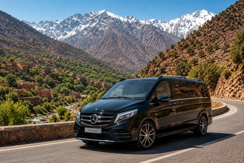 Escape the Marrakech Heat: Best Luxury Day Trips to Ouzoud Waterfalls and Ourika Valley Professional English-speaking private chauffeur opening the door of a premium luxury vehicle for international guests at a five-star oceanfront resort entrance in Taghazout Bay.